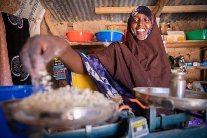 A person weighing cattle feed inside their family’s small shop.