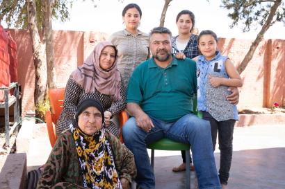 Multiple generations of family members posing together as a group.