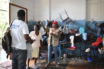 A mercy corps haiti mel team member making observations on the precarious conditions in which internally displaced people live.