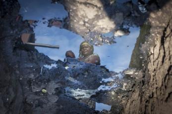 Image of a woman reflected in puddle in drc