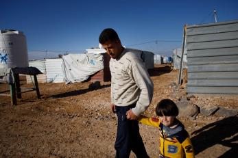 Ibrahim holding hands with his 3-year-old son, ahmad