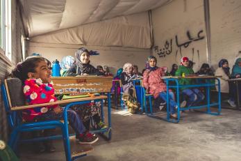 Malak sits comfortably in a zaatari classroom with her peers thanks to a custom-made desk designed for her.