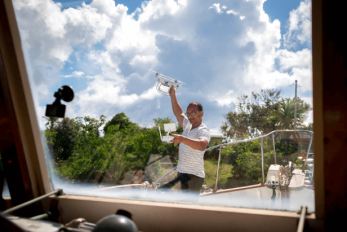 Miguel, 39, stands on the deck of his boat with his new drone.