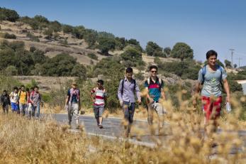 Refugees walk from the north of lesbos towards the port in the south that will take them to athens.