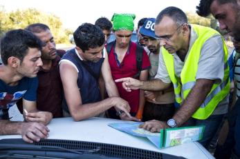 Mercy corps' mugur dumitrache gives a group of young men directions and information.