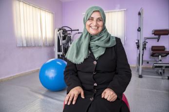 Leila sitting in a gym space in front of exercise equipment