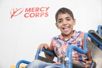 Ahmad seated at his desk, smiling