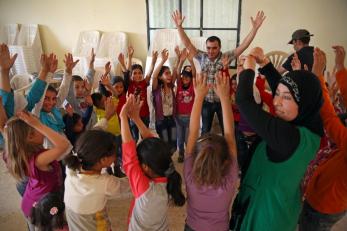 Group in a circle with arms raised