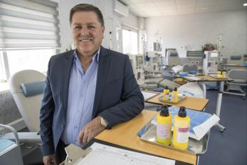 Dr. ibrahim leaning on a table next to medical supplies and a clipboard