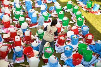 Mercy corps employee with buckets filled with supplies
