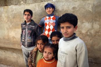 Children standing together in front of wall