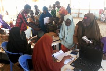 Returnees gathered at tables completing paperwork