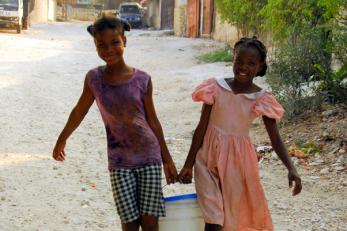 Two children carrying a bucket