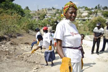 A woman working with other people to clear rubble