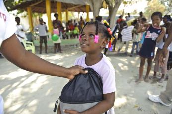 Girl receiving a bag of supplies