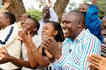 A group of people smiling and applauding. charles is at right.