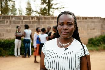 Annette in a white t-shirt with several people gathered in the background