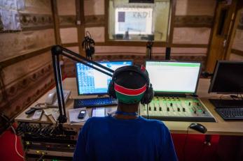 Ahmed wearing headphones and facing dj equipment