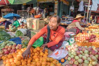 Woman selling fruit at an open air market in myanmar