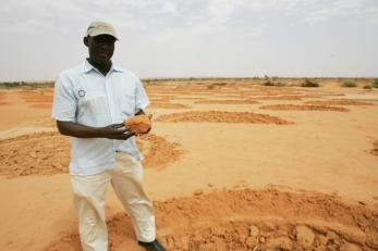 Mercy corps program manager moctar hamidou shows the half-moons that will allow the land to retain more water when rains return.