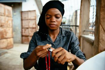 Rashidat working on a necklace