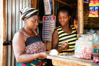 Charity taking to a customer at her shop