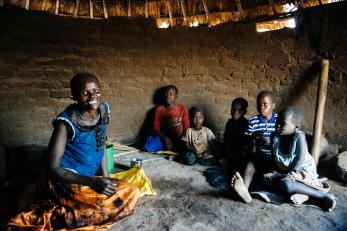 A woman seated with five young children