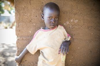 Guo’s 3-year-old son, nancy, hides around the corner of his family’s home.