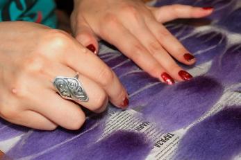 Hands over purple textiles