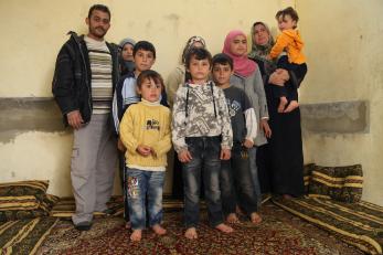 Abid with his wife and eight children in their one-room home.