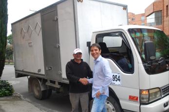 Two men shaking hands in front of a truck