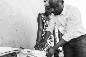 Man and woman putting their thumbprints on a piece of paper