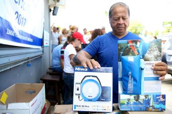 A man in puerto rico with a lantern and lifestraw, a water filtration device