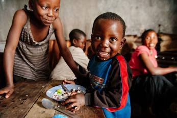 Child eating and smiling in drc