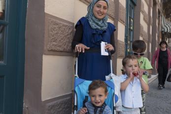 A woman with three young boys outside in greece