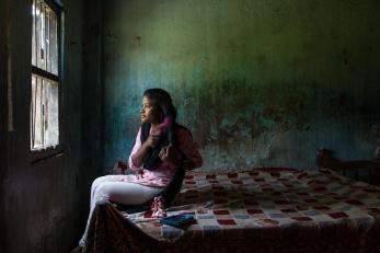 Teen girl in india sitting on her bed and brushing her hair