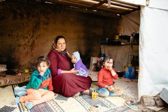 A woman with three young children sitting on the floor in lebanon