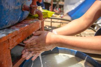 Soapy hands beneath a water tap