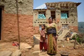 A girl holds the arm of a woman standing outside in nepal