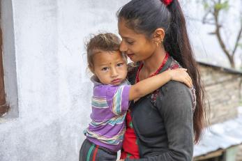 A woman holds a toddler in nepal