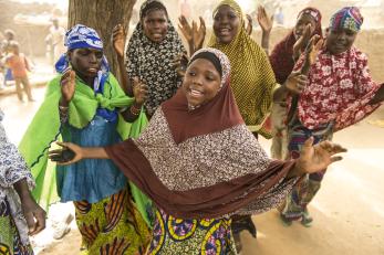 People singing with arms outstretched in niger