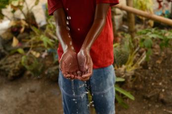 Hands cupped beneath a stream of water