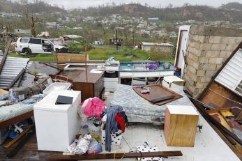 Kitchen, bed and other furniture exposed to the elements after the hurricane. the house has no remaining exterior or roof.