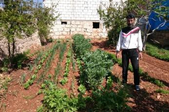 A farmer standing in his vegetable garden