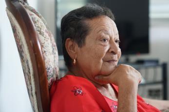 Portrait of carmen seated with her chin resting on her right hand.