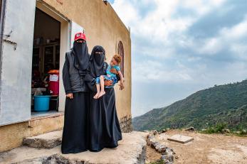 Two healthcare workers standing outside a building in yemen