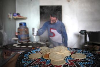 A man prepares round flatbreads in syria