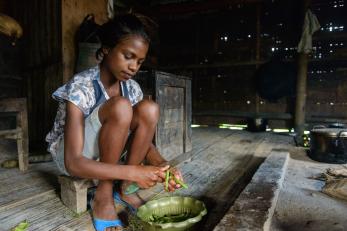 A girl prepares beans in timor leste