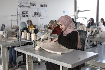 Jordanian women work in sewing company environment.