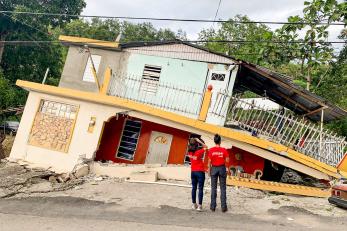 Mercy corps team members inspect a house damaged in the recent earthquakes.